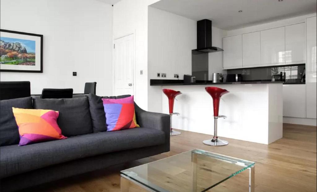 een woonkamer met een bank en een glazen tafel bij Clamshell Land - Royal Mile in Edinburgh
