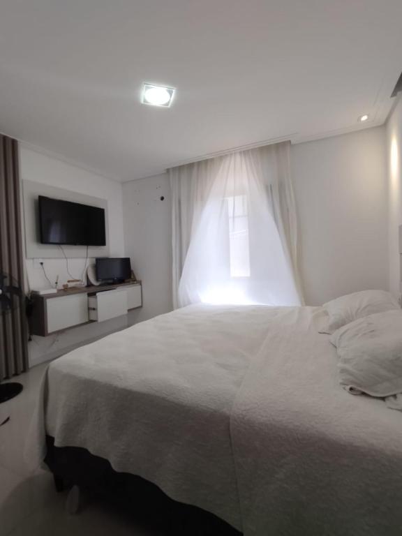 a bedroom with a large bed and a television at Casa Navega in Navegantes