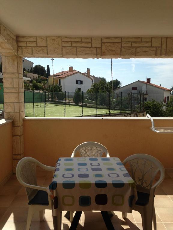einen Tisch und Stühle mit Blick auf einen Tennisplatz in der Unterkunft Apartments Villa Kristina in Pula