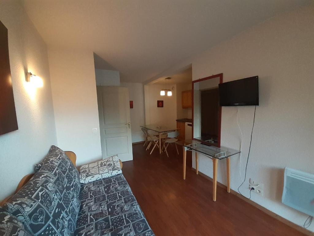 un salon avec un canapé et une télévision à écran plat dans l'établissement Appartement 3 pièces proche télécabine, 2 chambres, skis aux pieds, parking offert - FR-1-561-135, à Modane