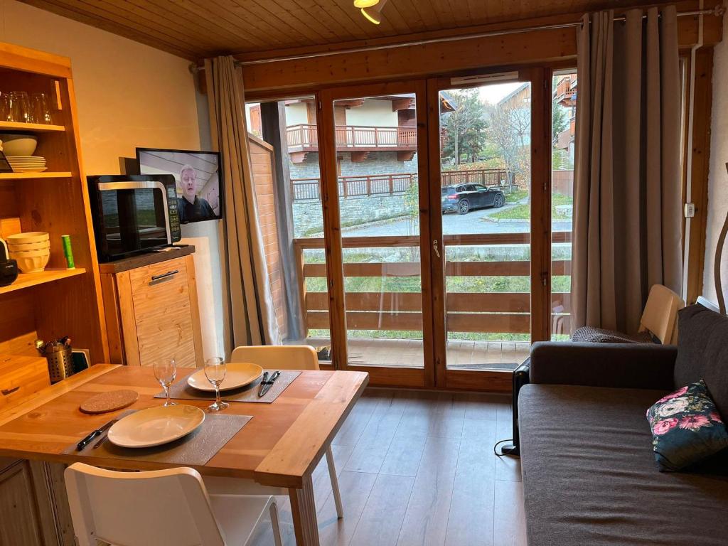 un salon avec une table en bois et une télévision dans l'établissement Studio confortable 3 pers. avec balcon à Valloire - FR-1-263-541, à Valloire