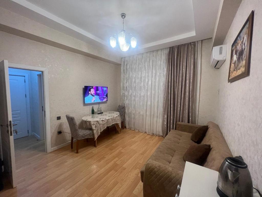 un salon avec un canapé et une table dans l'établissement Qələbə Rezident, à Baku