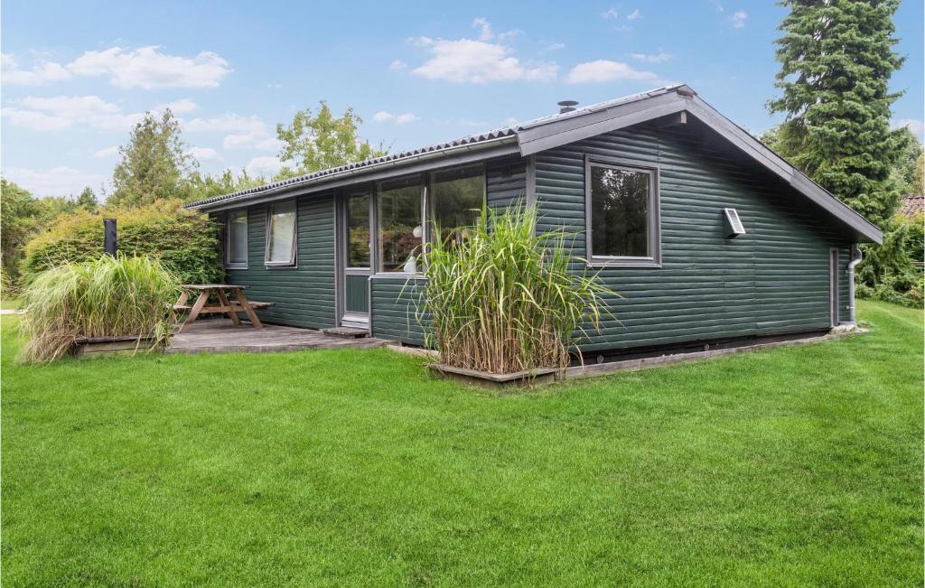 a green house with a lawn in front of it at Holiday Home Nysted 41 in Nysted