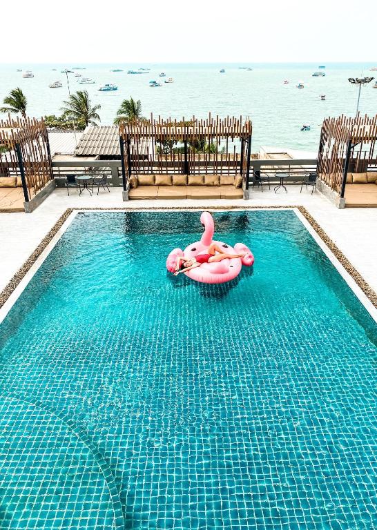 a swimming pool with a pink flamingo in the water at Hermann Hotel Pattaya in Pattaya