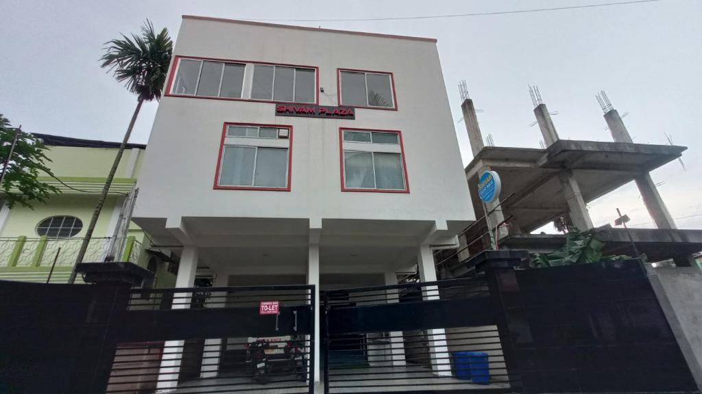 a white building with a sign on it at Shivam Guest House Near GNRC and Down Town Hospital in Dispur