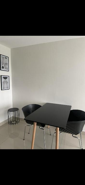 a table with two black chairs in a room at Umhlanga Modern Nest Studio in Durban