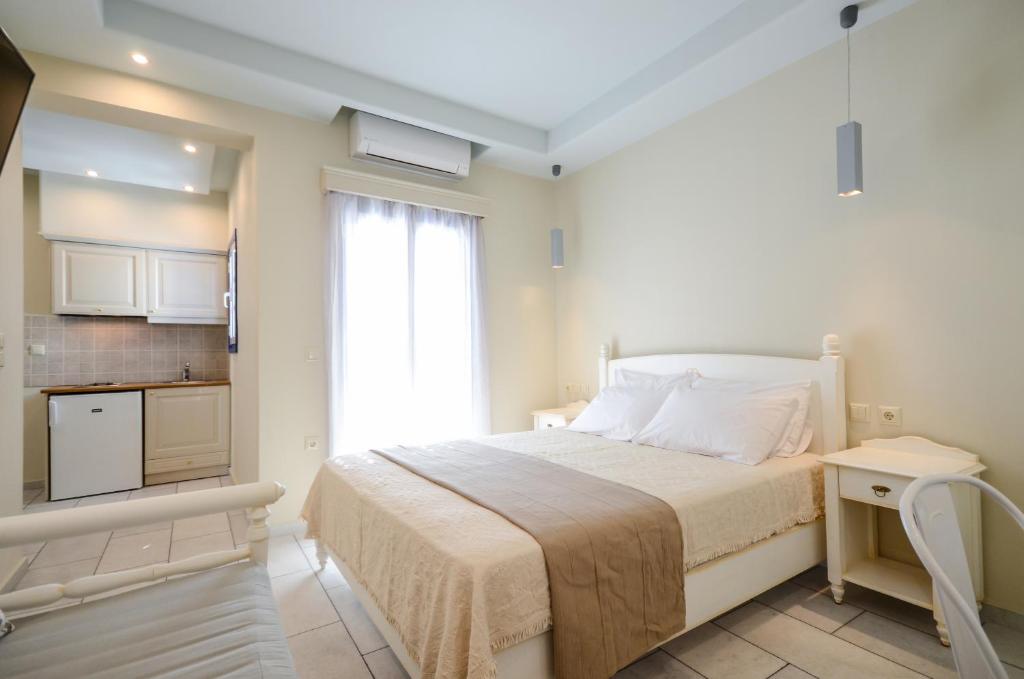1 dormitorio blanco con 1 cama y cocina en Vasilikos Studios, en Naxos Chora