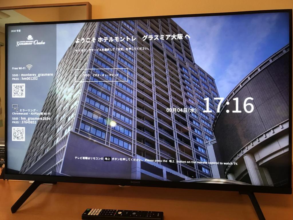 a television screen with a picture of a building at Hotel Monterey Grasmere Osaka in Osaka