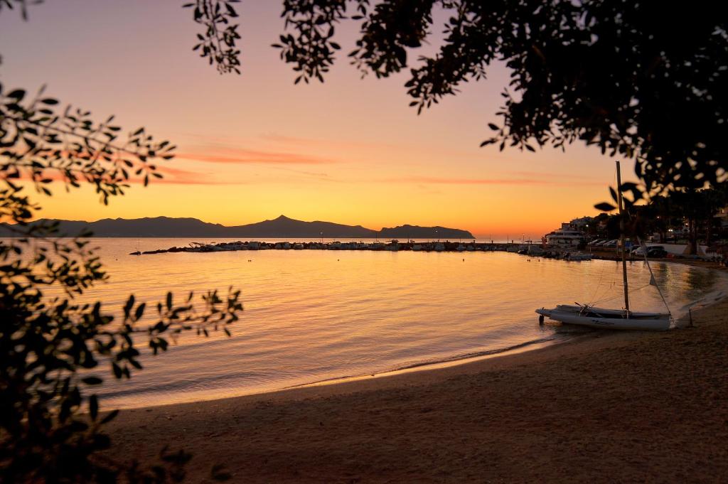 a boat sitting on the beach at sunset at Agistri Hotel in Skala