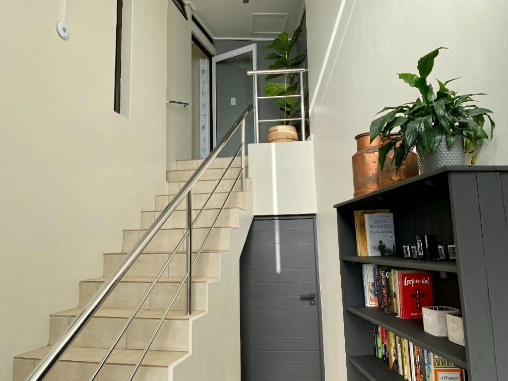 a staircase in a house with a book shelf at Rose’s Place in Durbanville