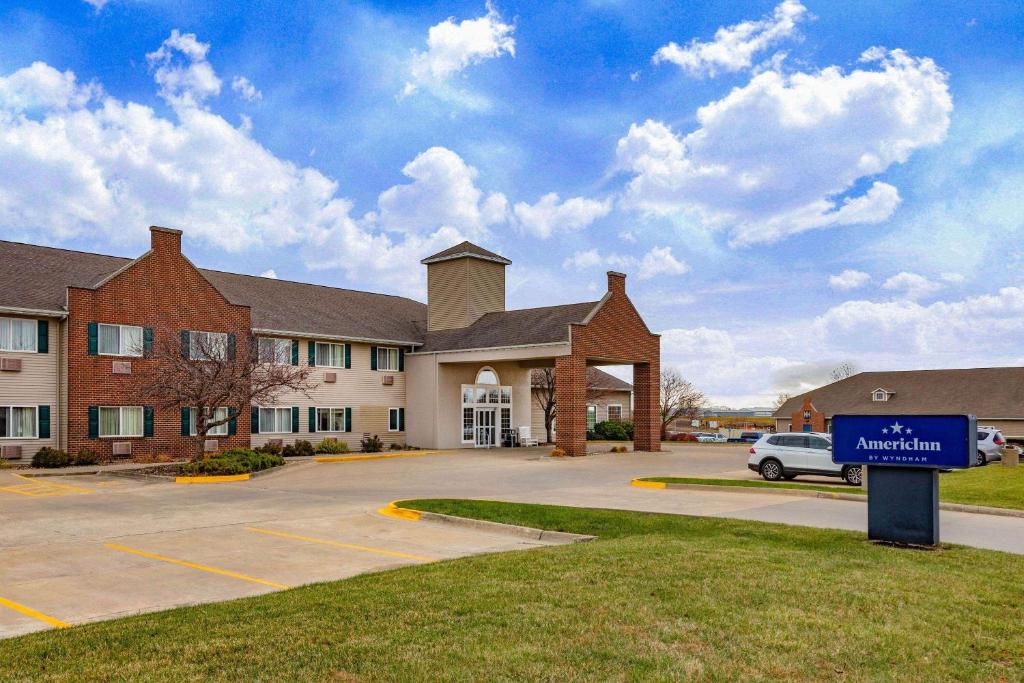 a building with a blue sign in front of it at AmericInn by Wyndham Pella in Pella