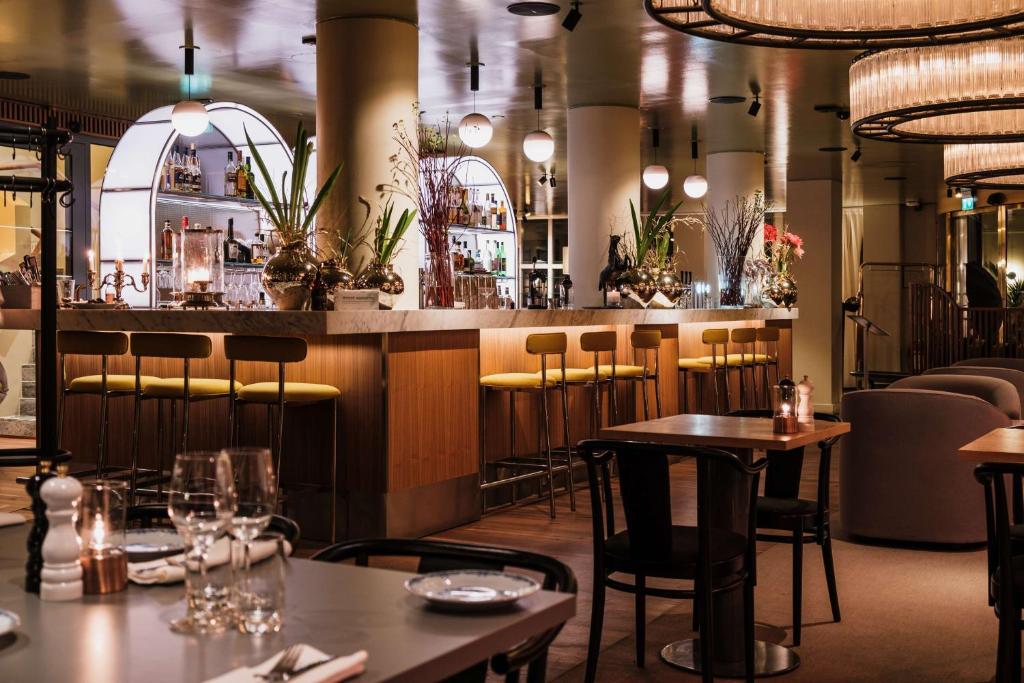 a restaurant with tables and chairs and a bar at Hôtel Reisen in The Unbound Collection by Hyatt in Stockholm