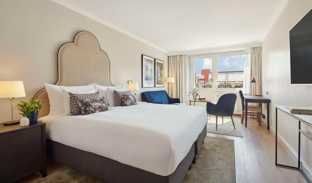 a hotel room with a large bed and a desk at Hôtel Reisen in The Unbound Collection by Hyatt in Stockholm