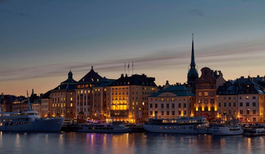 a city skyline with boats in the water at night at Hôtel Reisen in The Unbound Collection by Hyatt in Stockholm