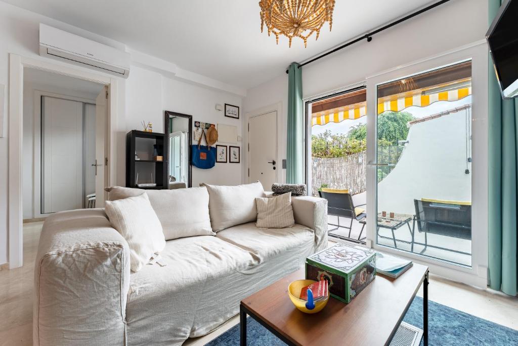 Una sala de estar con un sofá blanco y una mesa. en Mi Patio, Port Of Cabopino, en Marbella