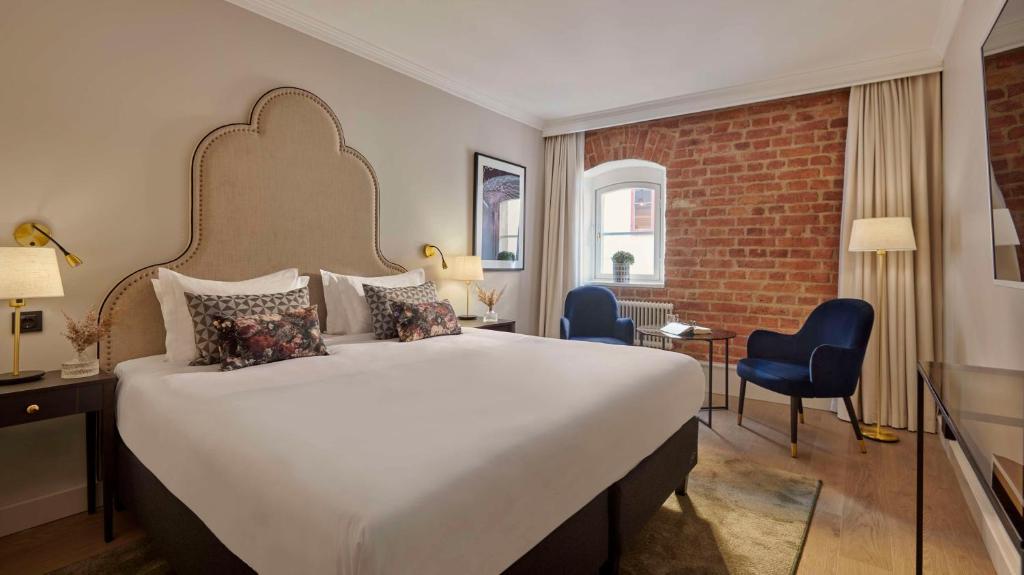 a hotel room with a large bed and chairs at Hôtel Reisen in The Unbound Collection by Hyatt in Stockholm