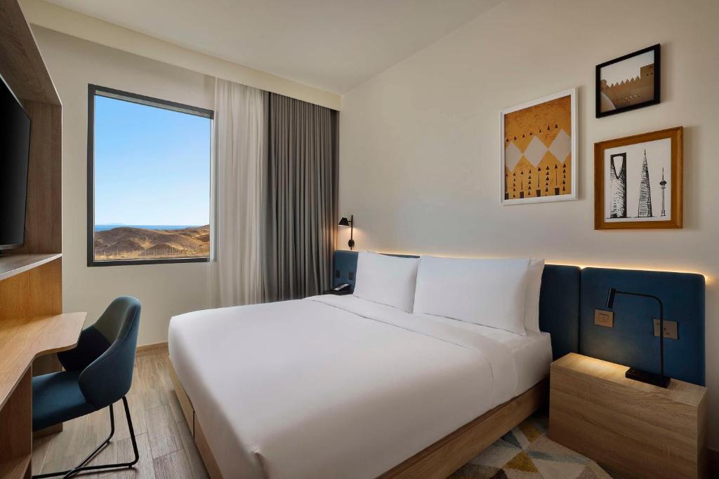 Postel nebo postele na pokoji v ubytování Hampton by Hilton Sharma NEOM Community 1