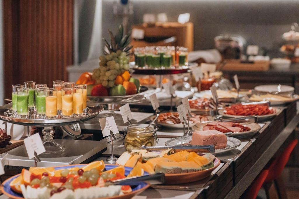 a buffet with many plates of food on a table at Hôtel Reisen in The Unbound Collection by Hyatt in Stockholm