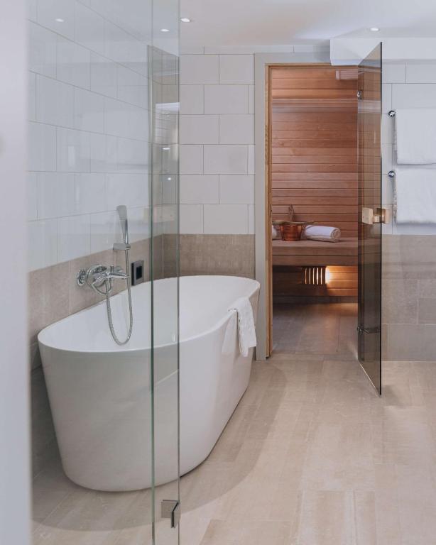 a white bath tub in a bathroom with a shower at Hôtel Reisen in The Unbound Collection by Hyatt in Stockholm