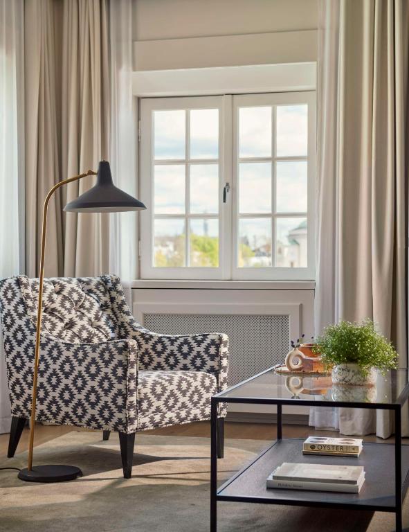 a living room with a chair and a table and a window at Hôtel Reisen in The Unbound Collection by Hyatt in Stockholm
