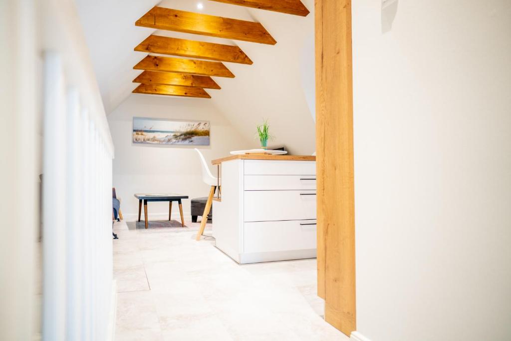 eine Küche mit Holzdecke und einem Schreibtisch in der Unterkunft Kapitänshaus - Boje in Born