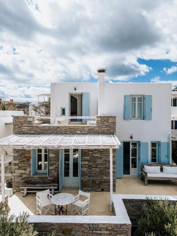 a white house with a patio with a table and chairs at Samanti House, Leivadi Serifos in Livadi