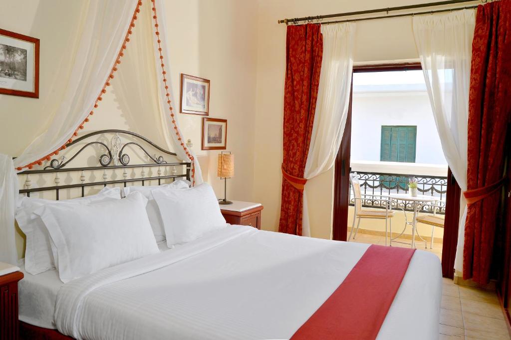 a bedroom with a white bed and a window at Agistri Hotel in Skala