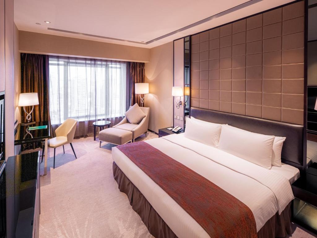 Postel nebo postele na pokoji v ubytování Grand Emperor Hotel