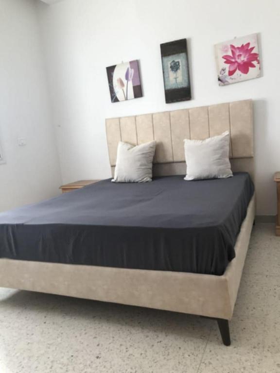 a bedroom with a large bed with blue sheets and pillows at Adam beautiful loft in Nabeul