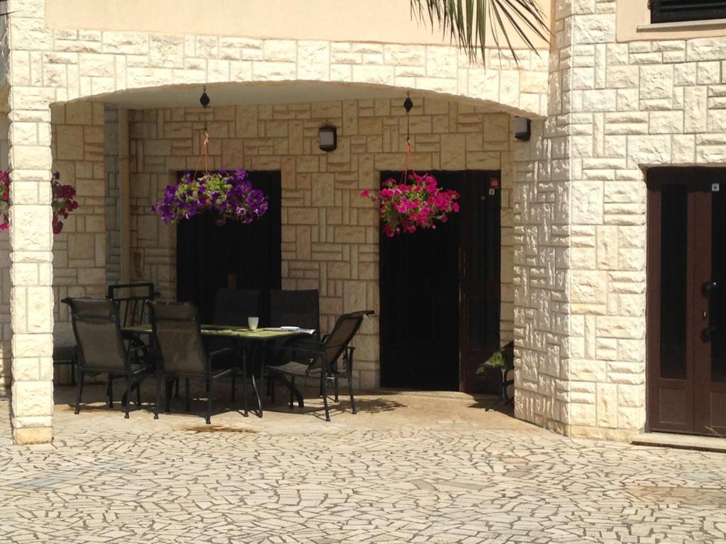 eine Terrasse mit Tisch und Stühlen und Blumen in der Unterkunft Apartments Villa Kristina in Pula