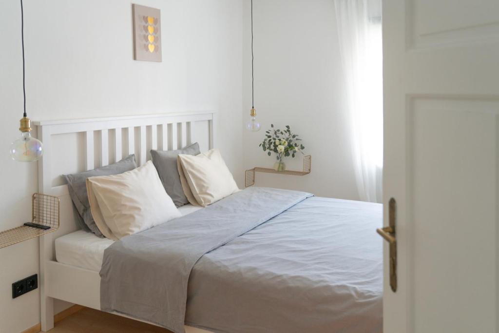 Un dormitorio con una cama con sábanas y almohadas blancas. en MIA Appartements, en Innsbruck