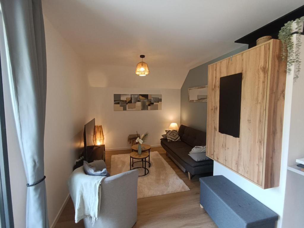 a living room with a couch and a table at Un Appart' à la campagne in Mordelles
