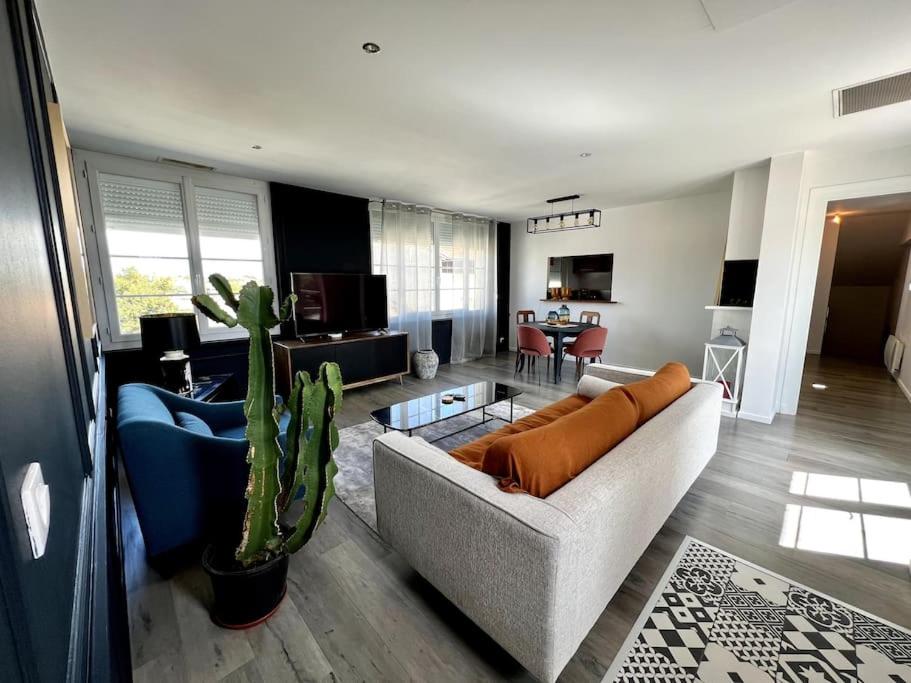 uma sala de estar com um sofá e um cacto em Superbe Appartement avec terrasse em Libourne