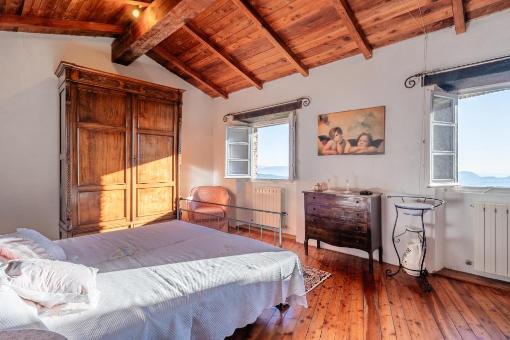a bedroom with a bed and a dresser and windows at Sunhouse - Tuscan Hills in Camaiore