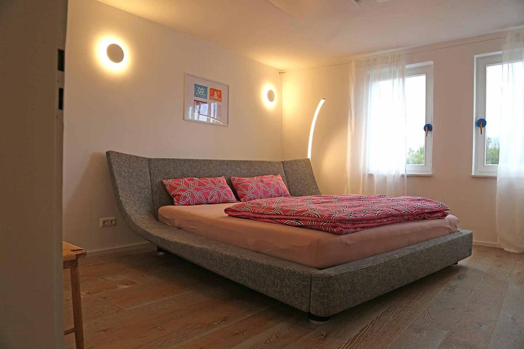 a bed with red pillows on top of it in a room at Ferienhaus Blaues Häuschen in Freudenberg am Main