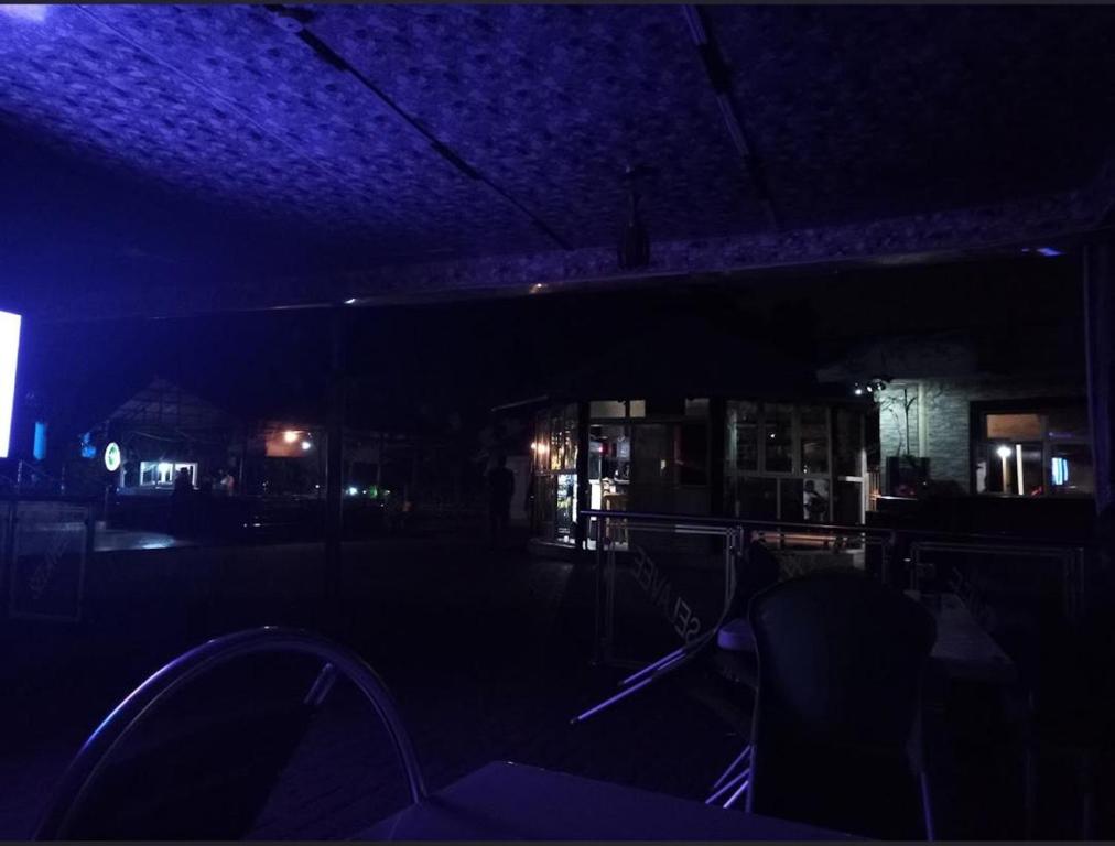 a dark room with a bar with purple lights at De-Boss Comfort Homes in Abuja