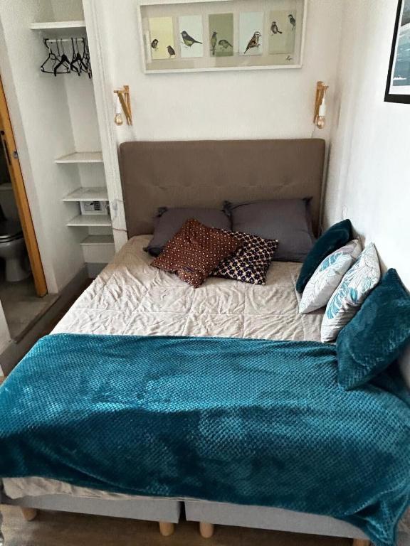 un lit avec des oreillers dessus dans une chambre dans l'établissement Le Centr’Aix-Studio au cœur d’Aix-les-Bains, à Aix-les-Bains