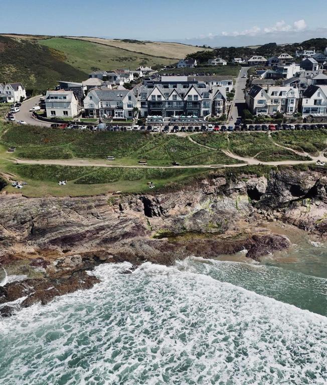 a group of houses on a cliff next to the ocean at Polzeath Beach House in Polzeath