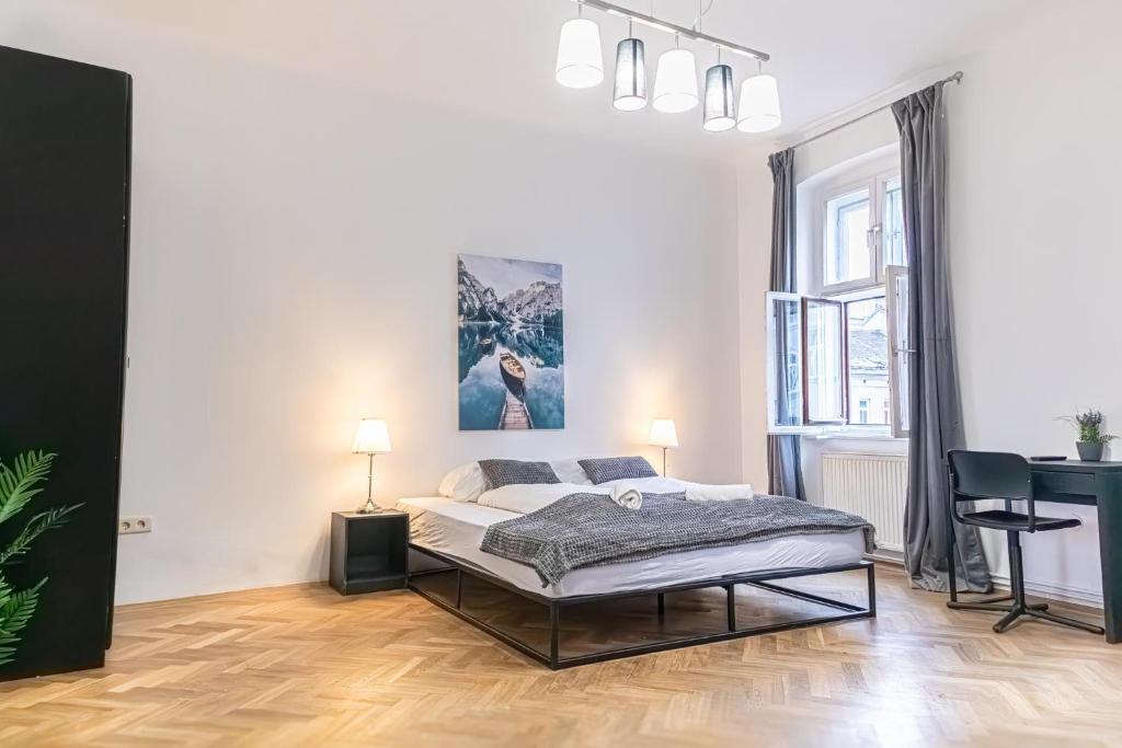 biała sypialnia z łóżkiem i biurkiem w obiekcie Spacious 2BR Apt -Near Wiener Stadthalle BurggasseWiener Well Located w Wiedniu