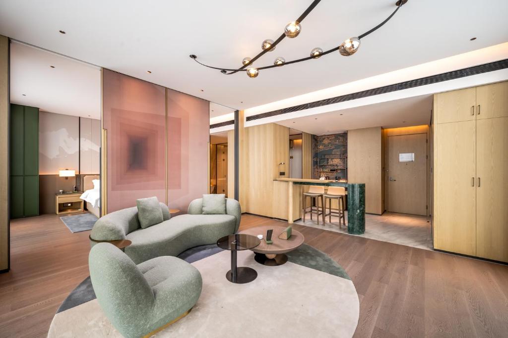 a living room with a couch and chairs and a table at Qinglian Jinghe Hotel Wuhan Zoo International Expo Center Branch in Han-yang-hsien