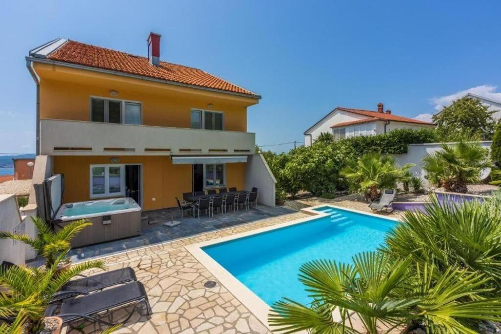 a villa with a swimming pool in front of a house at House Moderna 2 in Crikvenica
