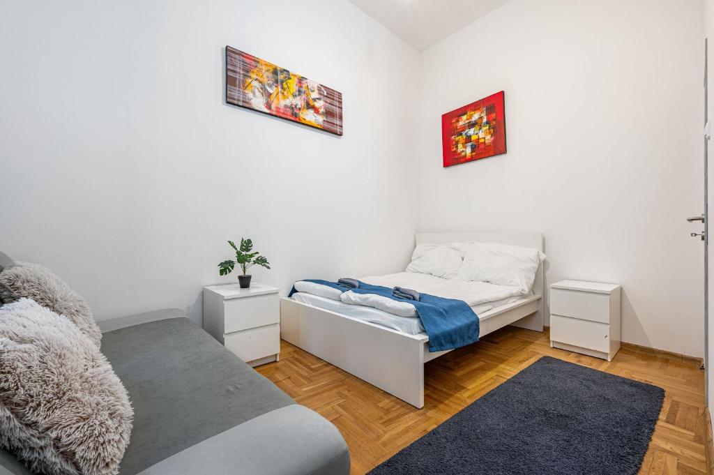 Un dormitorio blanco con una cama y un sofá. en M&M Apartment - Ferenciek tere, en Budapest