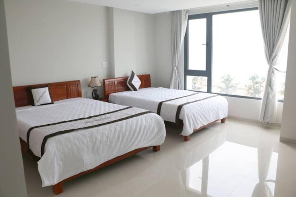 Postel nebo postele na pokoji v ubytování Huy Hoàng Hotel Đà Nẵng