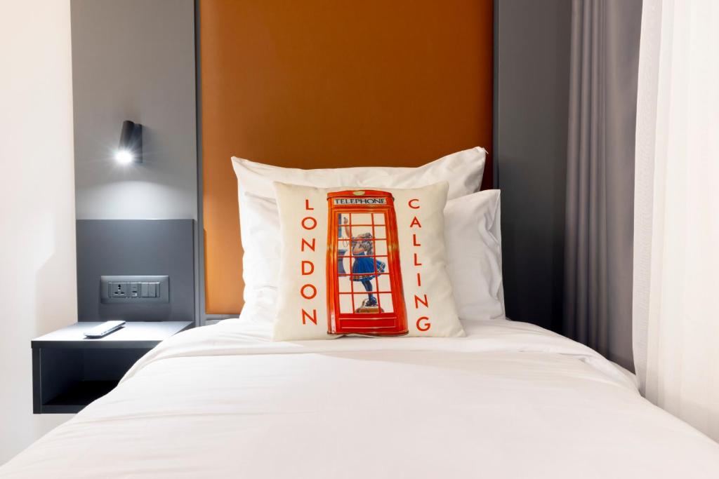 a bed with a red phone booth pillow on it at The Londoner Hotel St. Julian's in St. Julianʼs