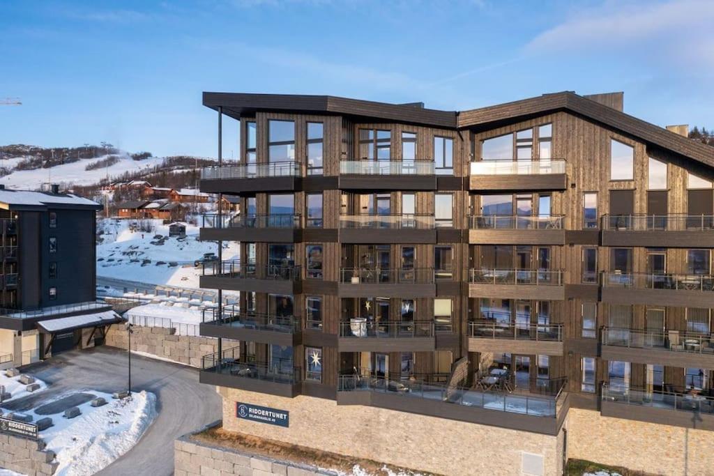 une vue aérienne d'un immeuble d'appartements avec de la neige dans l'établissement Riddertunets hygge, à Beitostøl