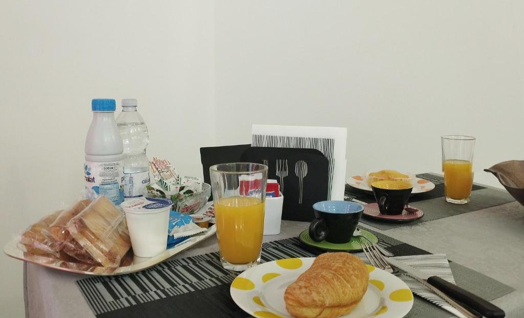 a table topped with plates of food and orange juice at San Giovanni Apartment in Catanzaro