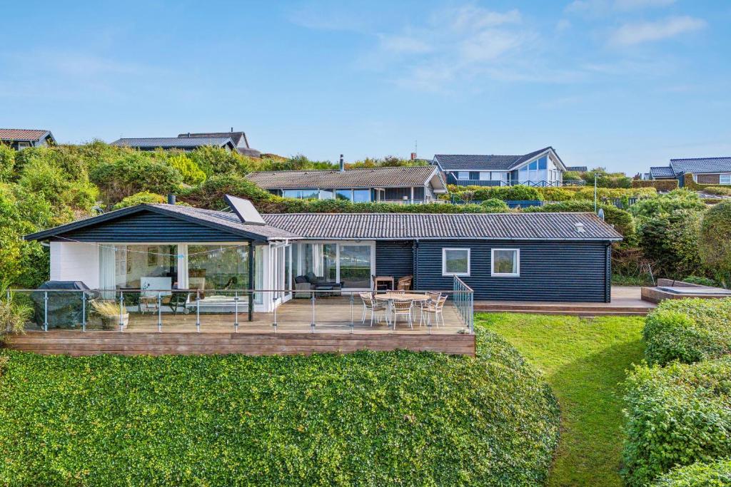 una casa azul con terraza en un patio en Stunning Home In Ebeltoft With 3 Bedrooms And Internet, en Ebeltoft