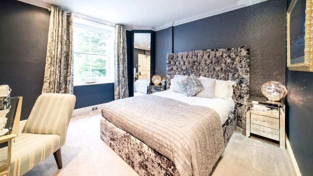 a bedroom with a bed and a chair and a window at Derby Manor in Bournemouth