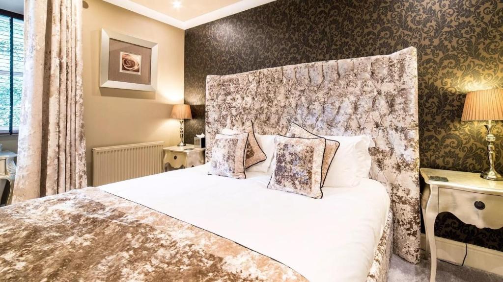 a bedroom with a white bed with a headboard at Derby Manor in Bournemouth
