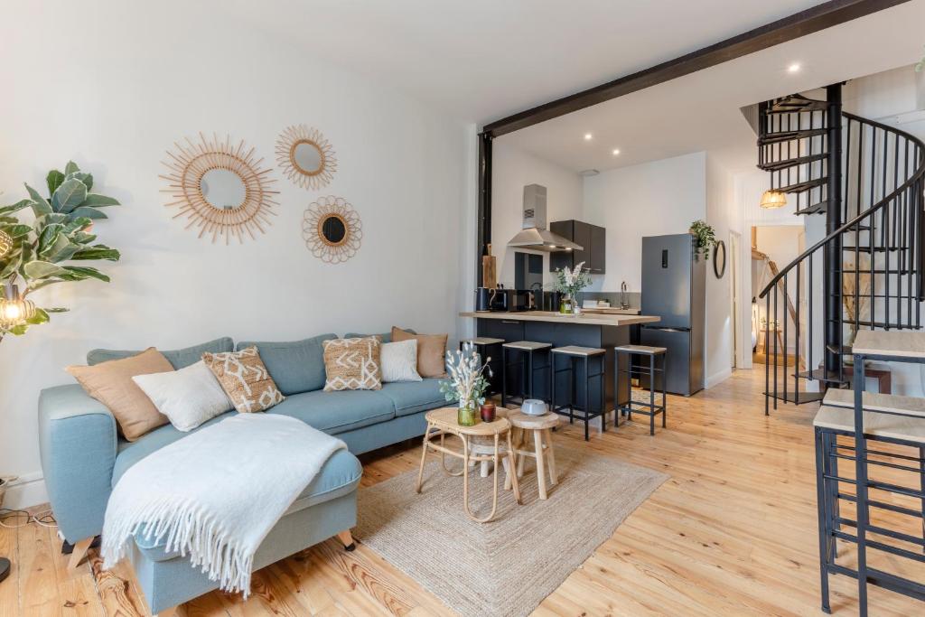 un salon avec un canapé bleu et une cuisine dans l'établissement Duplex des Halles 3 chambres, à Pau